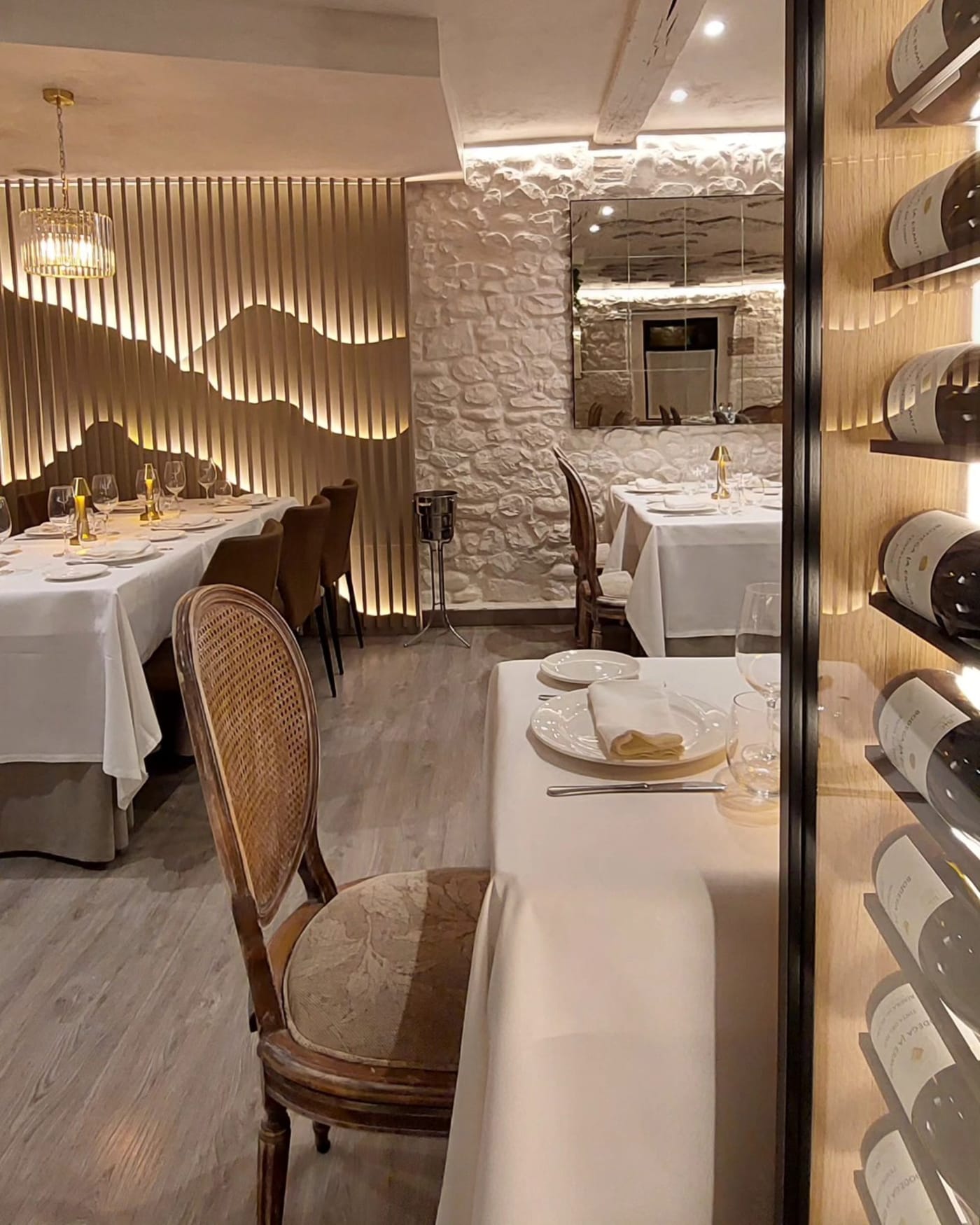 Vinoteca de La Casuca del Gorbea con botellas y mesas vestidas de blanco